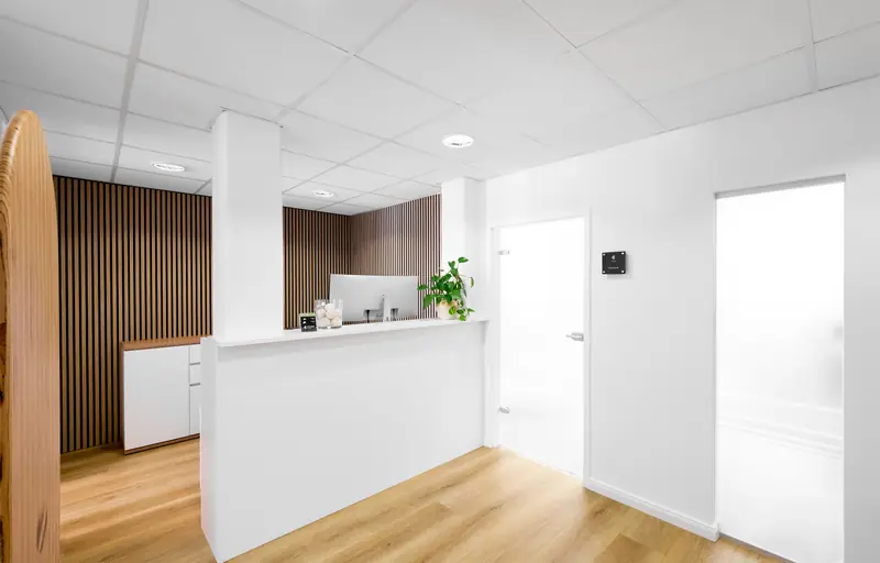 Bright reception desk at FLOW Physiotherapie with wooden slats